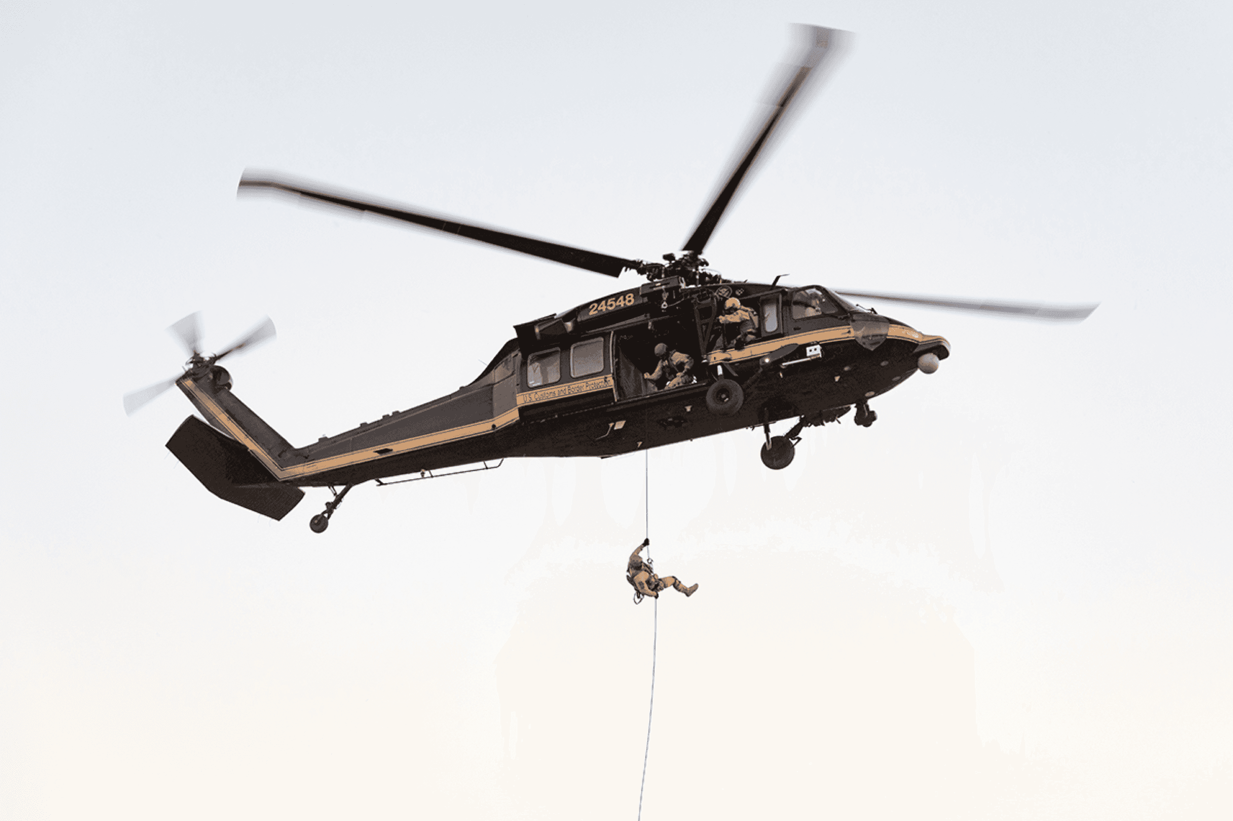 Agente de policía desciende del helicóptero durante una operación con un programa informático de inteligencia